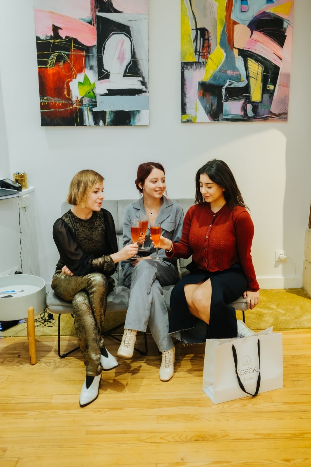 Three clients toasting in front of contemporary art in a private Paris space